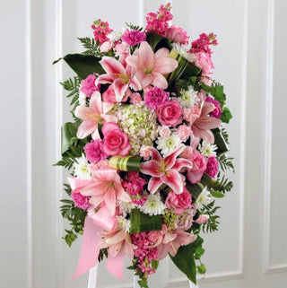 Sympathy floral standing spray arrangement featuring pink lilies and soft pink roses