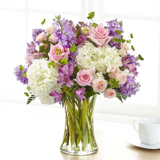 Beautiful vase arrangement with white hydrangea, pastel pink spray roses, and lavender stock bouquet