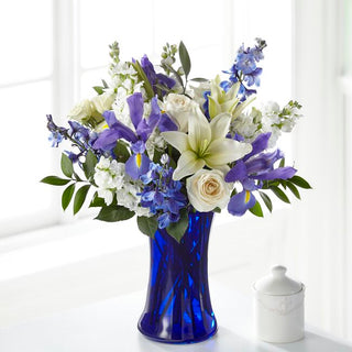 Send peaceful white and blue sympathy flowers in a blue vase. Thoughtfully arranged and available for delivery in Vaughan. Order online today.