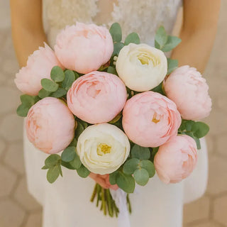 Romantic wedding bouquet featuring blush pink peonies and white flowers with fresh greenery, designed for brides seeking a soft, timeless floral look.