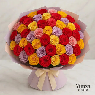 Luxury 50 mixed roses bouquet in vibrant red, yellow, pink, and lavender tones, elegantly wrapped in premium pastel florist paper with satin ribbon — handcrafted fresh flower arrangement by Yunza Florist Toronto