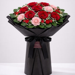 Midnight Romance bouquet with red roses, pink carnations, mini carnations, and baby’s breath in elegant black wrapping by Yunza Florist Toronto