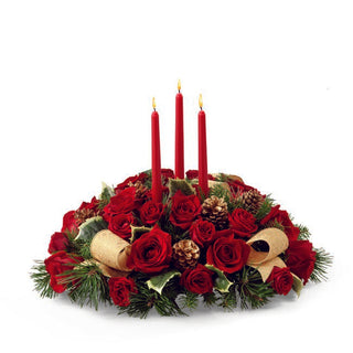 Holiday table centerpiece featuring red roses, pinecones, and shimmering gold details