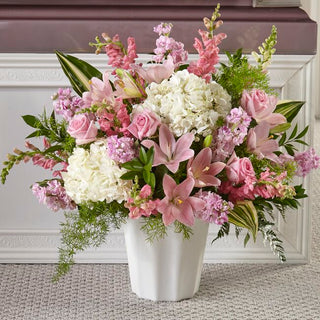 Luxury funeral floor basket flower arrangement with white lilies, roses, and greenery for sympathy