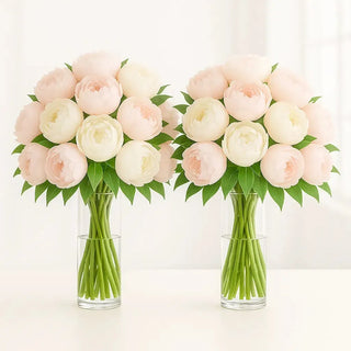 Elegant pair of peony reception arrangements in tall glass vases with blush and white peonies accented by lush greenery. Perfect wedding centerpieces for receptions and events in Toronto.
