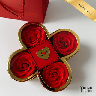 Yunza Florist Lucky Charm Secret Bloom red clover-shaped soap rose box, shown open to reveal four red soap roses and the central hidden compartment with a ring display stand.