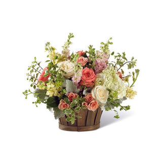 Pastel flower basket with peach and ivory roses, hydrangea, stock, snapdragons and lush greenery