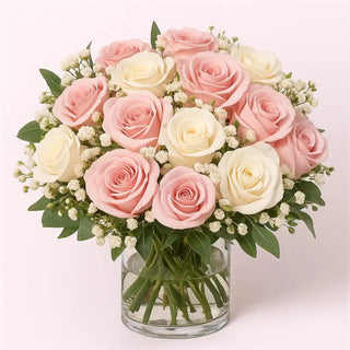 Wedding reception floral arrangement featuring pink and white roses with greenery and baby’s breath